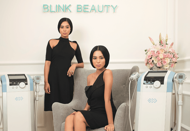 Maria & Elizabeth Rahajeng wearing black dresses at Blink Beauty Clinic next to Exilis Ultra machines.